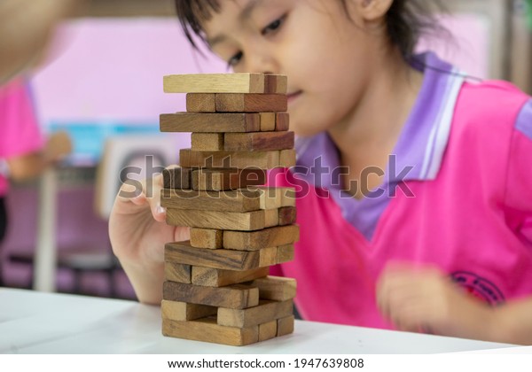 The tower stack from wooden\
blocks toy on table in classroom. Infant developmental\
accessories.