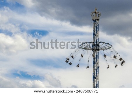 Tower Swing Ride Against a Dramatic Cloudy Sky