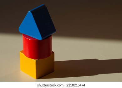 Tower of wooden blocks. House construction, children's game, natural materials for the production of toys. Basic colors - red, yellow and blue. Basic shapes - square, triangle and circle. Cylinder. - Shutterstock ID 2118215474