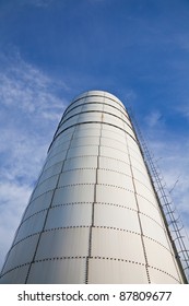 Towering grain silo under blue skies.