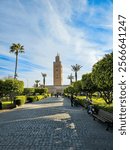 Towering minaret of the Koutoubia Mosque in Marrakesh, Morocco, featuring intricate Islamic geometric patterns and vibrant tilework against a vivid blue sky.