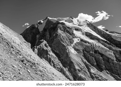 The towering Ortles Mountain stands grand under blue skies, its snowy caps and rugged terrain evincing the serene beauty of the Italian Alps. Black and white photography. - Powered by Shutterstock