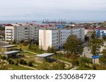 The town of Korsakov, Sakhalin Oblast, Russia. View of residential buildings and city yards. In the distance is a cargo seaport. Korsakov is located in the south of Sakhalin Island. Russian Far East.