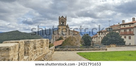 A town in Spain called Frías, beautiful constructions, paved, with its chapel and church, most of them built in stone. With cloudy sky.