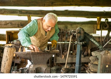 Townsend, TN/April 20, 2019:  Artisan works in the woodworking sTownsend, TN/April 20, 2019:  Male Artisan works in the metalworking shop at Mountain Farm Museum at Great Smoky Mountain National Park 