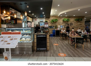 Townsville, Queensland, Australia - November 2021: Customers Dining At A Popular Coffee Shop With Food Display Cabinet