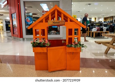 Townsville, Queensland, Australia - November 2021: Tiny Orange Painted House With Flowers At Busy Shopping Center