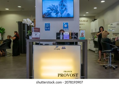 Townsville, Queensland, Australia - November 2021: Brightly Lit Sign At Hairdressing Salon With Staff Attending To Female Customers Hair