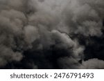 Toxic black smoke from fire against sky, burning plastic