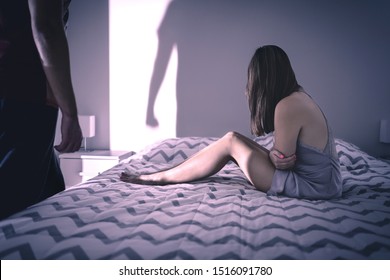 Toxic Relationship With Domestic Violence. Upset Victim Defenseless On Bed. Sexual Abuse, Rape. Dysfunctional Fighting Couple With Issues. Evil Psychopath Man. Battered Woman. Shadow Of Fist On Wall.