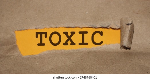Toxic word uner Brown torn paper with yellow background. Addictions, quit smoking and drinking, bad habits and toxic relationship concept.