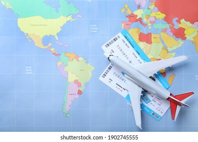 Toy Airplane And Tickets On World Map, Flat Lay. Travel Agency Concept