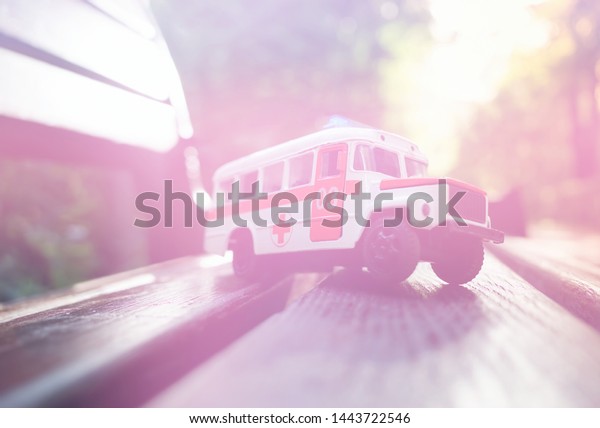 Toy\
ambulance car in glowing light leak\
background