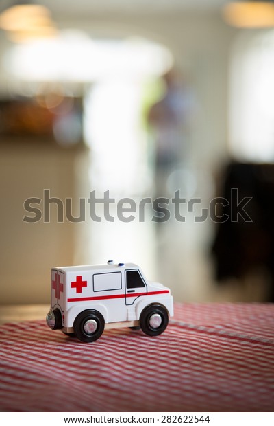 toy ambulance close up with blurred\
background. Tabletop in a\
restaurant.\
