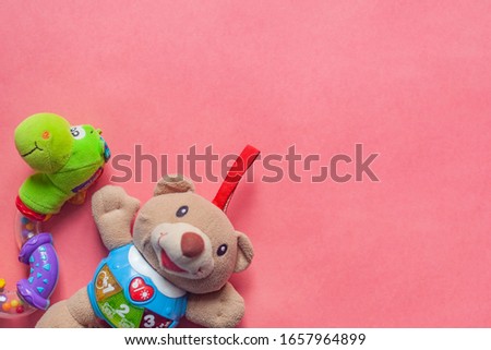 Toy for baby. Teddybear for baby on pink background. Top view. Copy space