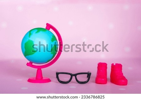 Toy black glasses, pink boots and globe close-up. Back to school concept. High quality photo