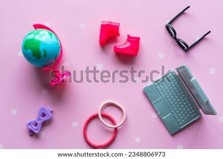 Toy black glasses, pink boots, laptop and globe close-up. Back to school concept. High quality photo