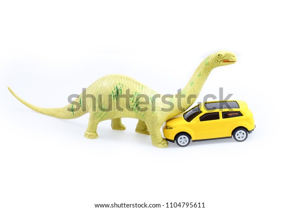 Toy Brachiosaurus dinosaur attack yellow car\
isolated on white\
background