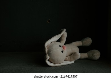 Toy bunny lies alone in a room. War, death and lost childhood concept.
