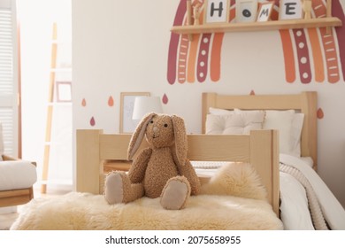 Toy Bunny On Faux Fur In Modern Girl's Bedroom. Interior Design