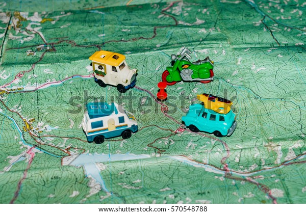 Toy buses and motorcycles are on a map in this\
Stationery button location