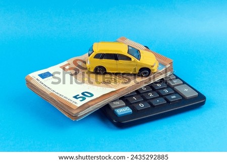 Toy car and banknotes. Determining the price of the machine to purchase. The price of the machine. Blue background.
