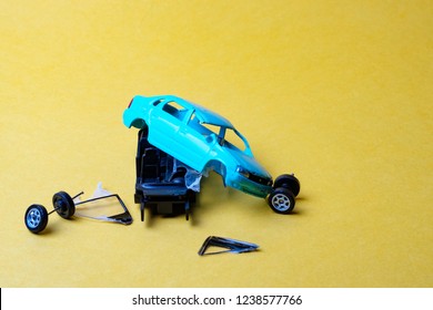 Toy Car Broken Into Pieces, Wheels And Glass Fell Off, Yellow Background