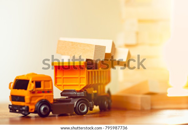 The toy car\
and building truck on wooden\
table