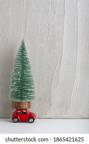 Toy Car With Christmas Tree On Roof. Car As Gift Under The Tree. Vertical Frame.