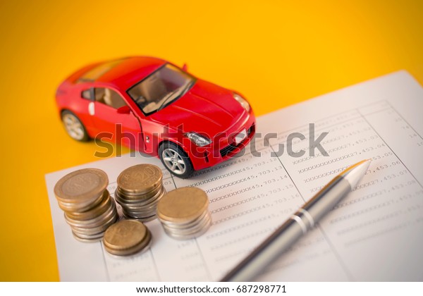 Toy car with coins stack and saving book - Auto\
loan concept