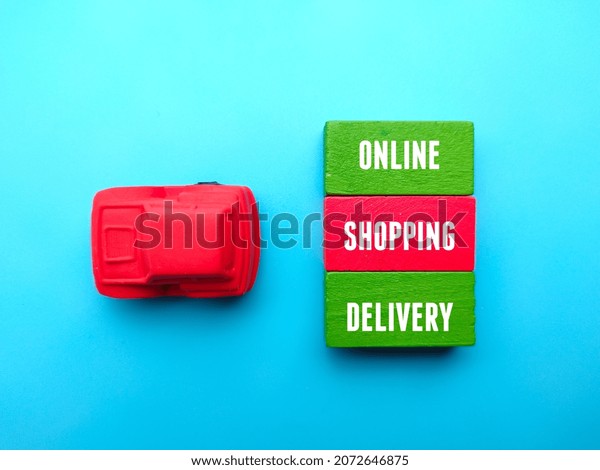 Toy car and colored cube with text ONLINE\
SHOPPING DELIVERY on blue\
background.