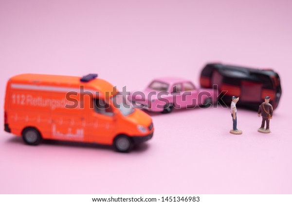 Toy car crash with miniatures of people.\
Insurance concept