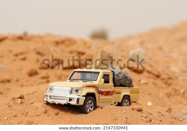 A toy car in the desert.\
