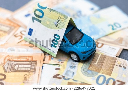 Toy car and euro on white