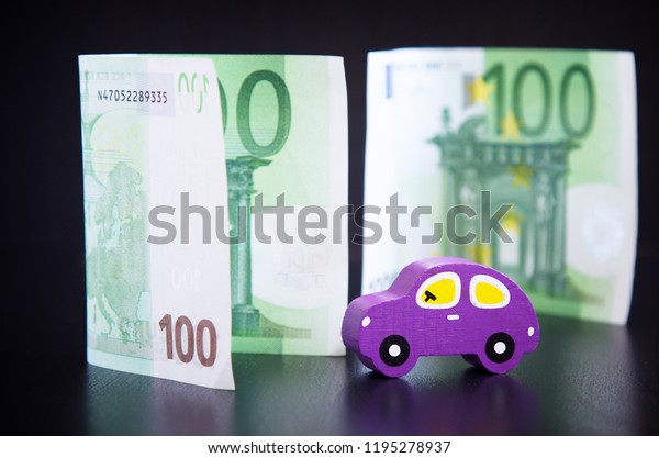 Toy car and euros on\
black background