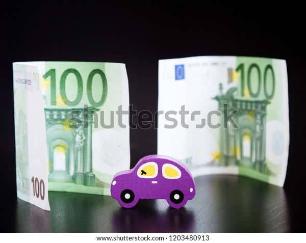 Toy car and euros on\
black background