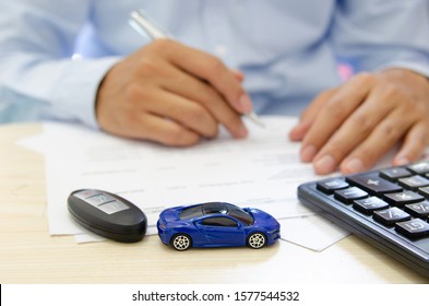 Toy car finance calculator, car keys and papers on the desk.car insurance concept - Shutterstock ID 1577544532