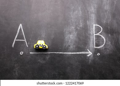 Toy Car Illustrating Going From A To B On A Blackboard.