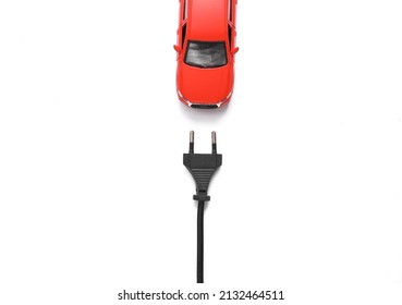 Toy car model with an electric plug on a white background. Electric car