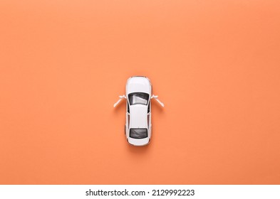 Toy Car Model With Open Doors On Pink Background. Top View