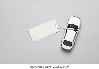 Toy car model with price tag on a gray background. Top view - Shutterstock ID 2266535409