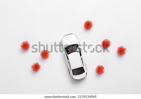Toy car model with a virus\
strain on white background. Protect your health concept. Top\
view