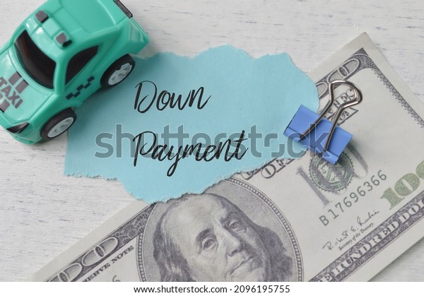 Toy car, money banknote and torn paper with text\
DOWN PAYMENT