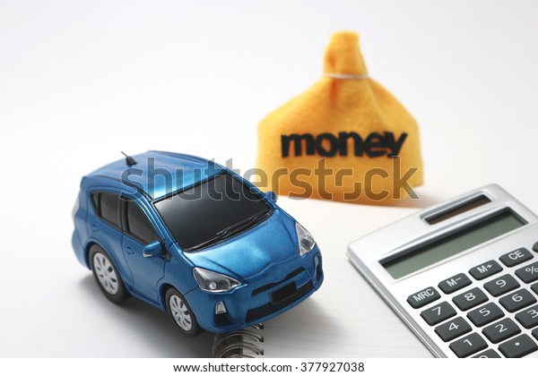 Toy car, money and calculator\
isolated on white background. Rent, buy or insurance car\
concept.