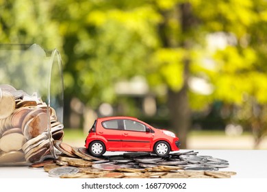 Toy Car And Money Coins In Glass Jar