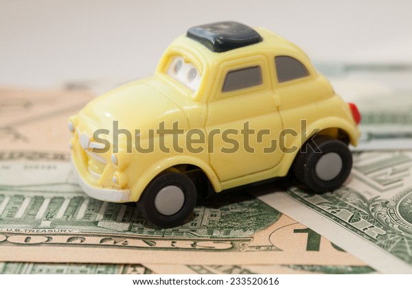 Toy car on a\
background of US dollars\
banknotes