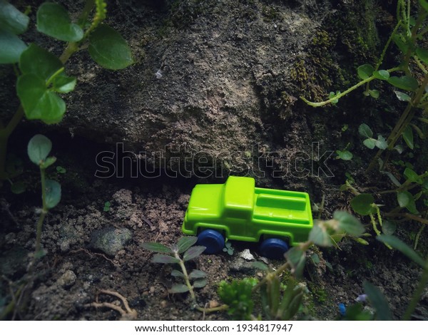 a toy car is on a\
cliff in the forest