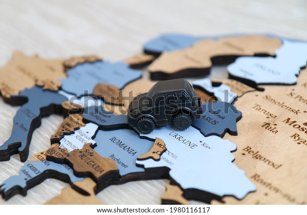 Toy car on a wooden map\
background. Automobile travel and tourism concept. Europe close\
up