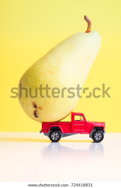 a toy
car on a yellow background. transports a
pear