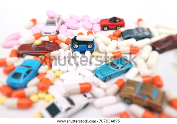 Toy car\
overturn with pill on pile of capsules medicine, miniature cars\
turns different direction on heap of pills \
